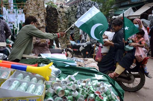 People buying national flags at Paper Market ahead of National Day of Pakistan